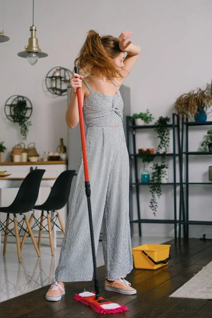 A red vacuum cleaner on a carpet in a stylish home setting with barefoot user.